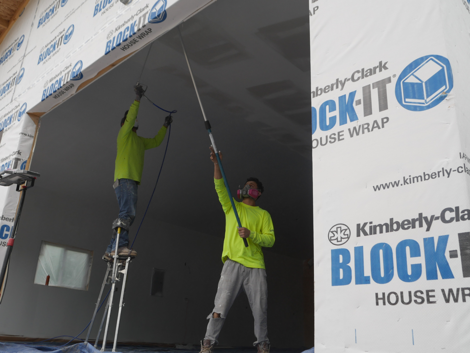 Great Lakes Drywall two-person crew hanging and finishing a high ceiling on an Illinois drywall installation
